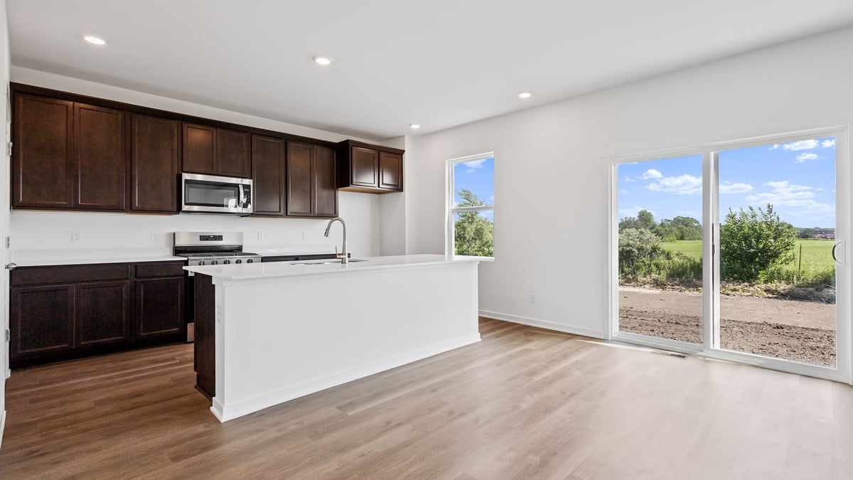 Kitchen and dining area with a window and glass sliding door.