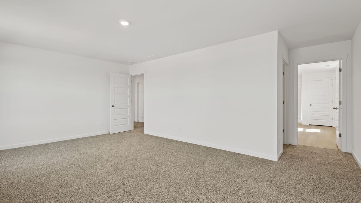 Primary bedroom with carpeted floors and great amounts of space.
