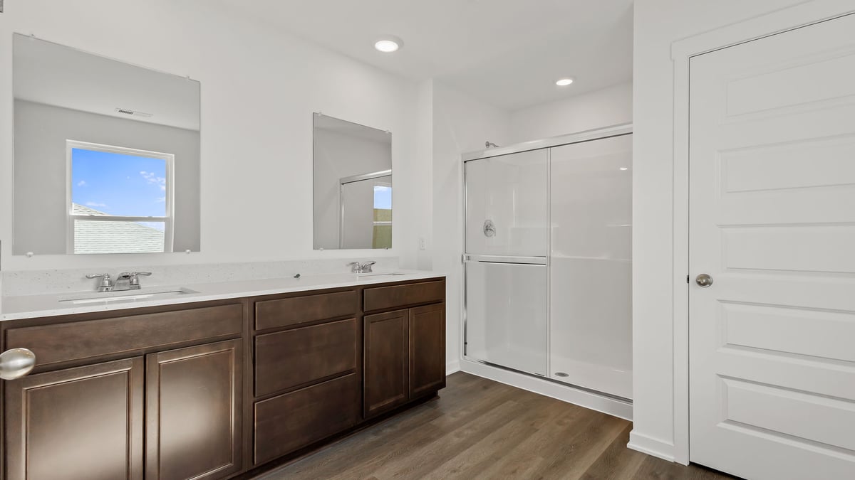 Primary bathroom with dual vanity sink and a walk-in shower.