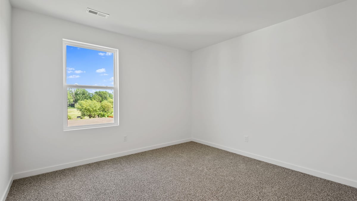 Bedroom with carpeted floors and a side window.