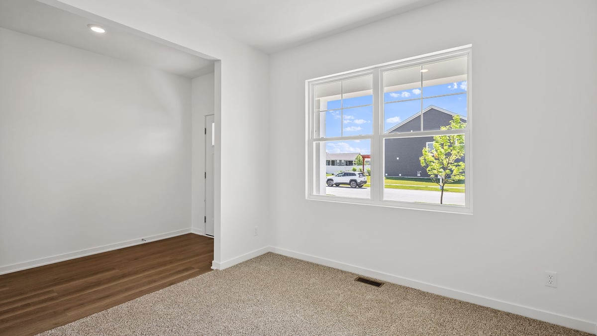 Front room with carpeted floors with a big window.