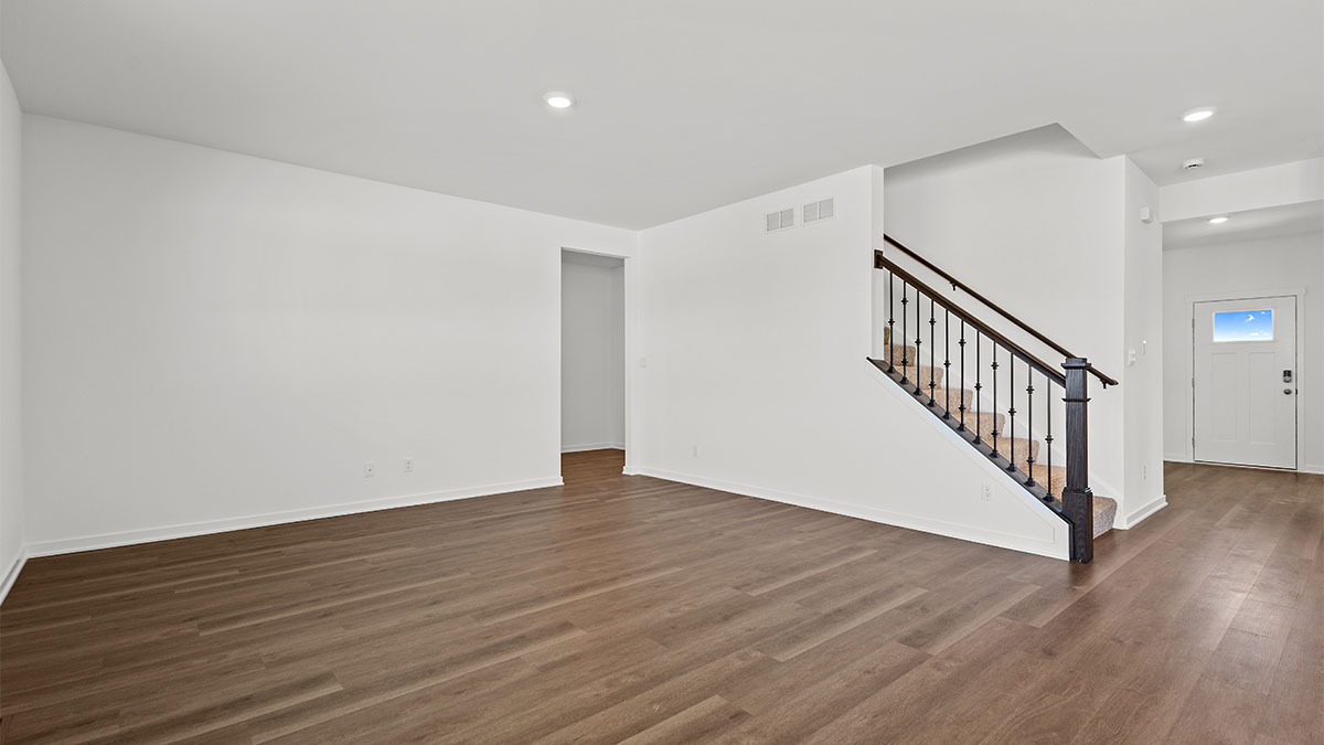 Living room with open layout and view of open staircase.