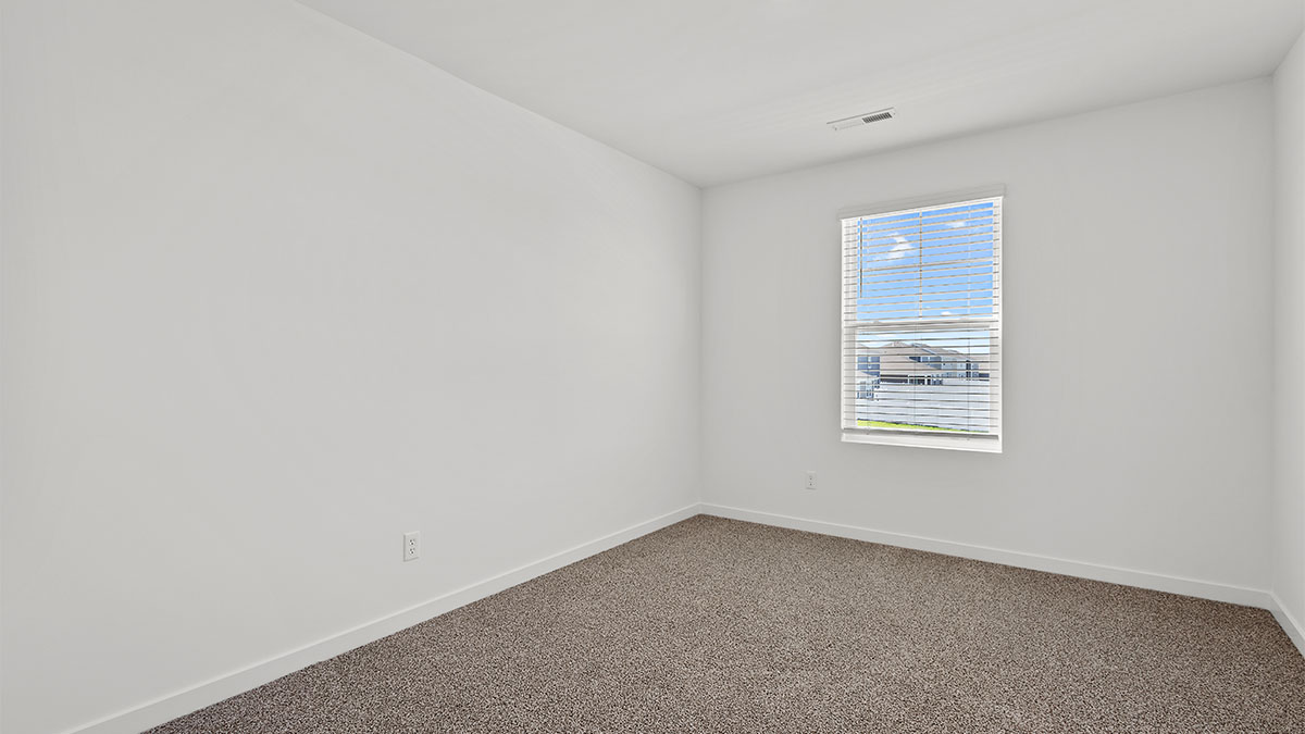 Bedroom with carpet and a window.