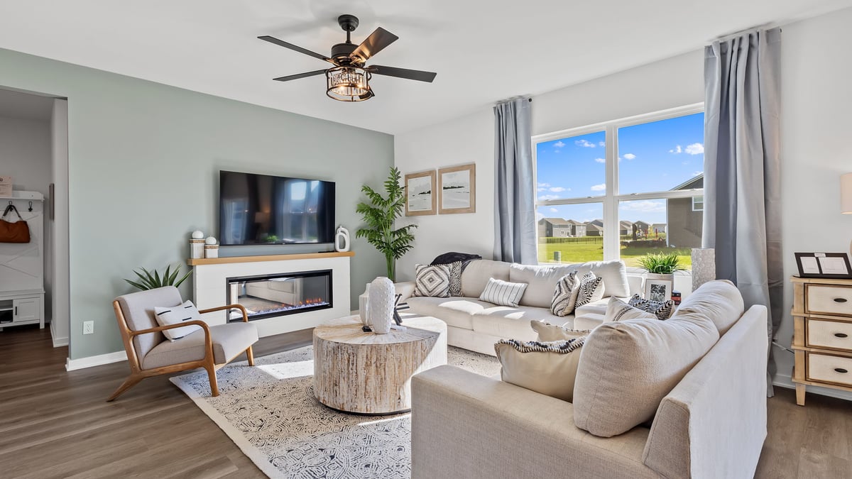 Living room area with a big window and hard wood flooring.