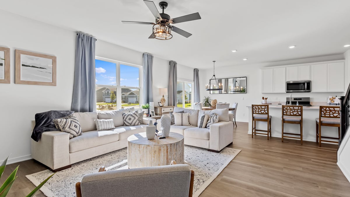 Living room space with big windows viewing the dining and kitchen area.