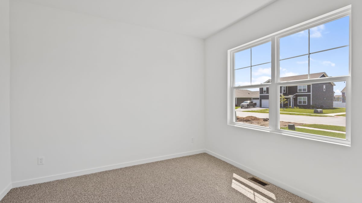 Front room with a big window and carpeted floors.