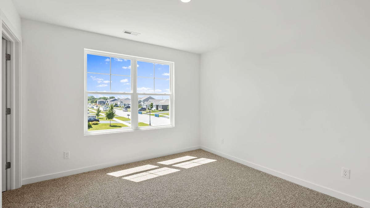 Bedroom with carpeted floors and a big window.