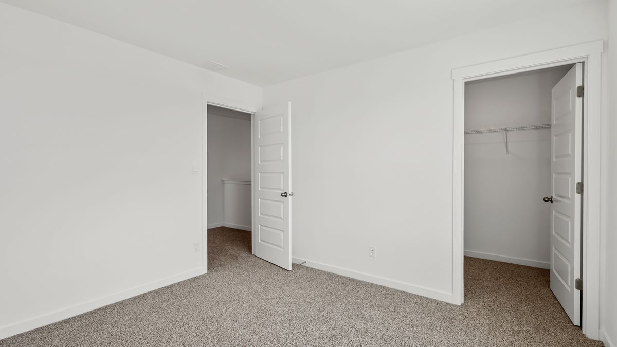 Bedroom with carpeted floors and own closet.