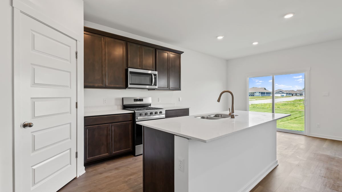 Kitchen with hard wood flooring and a glass sliding door.