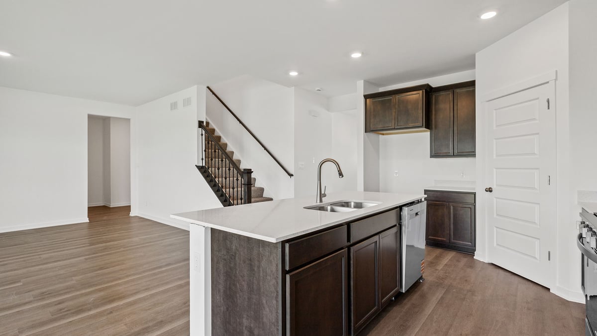 Kitchen island with quartz countertops and hard wood flooring.