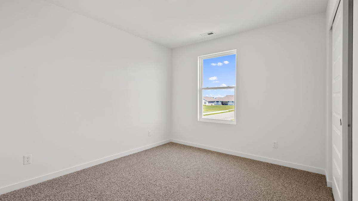 Bedroom with carpeted floors with a side window.