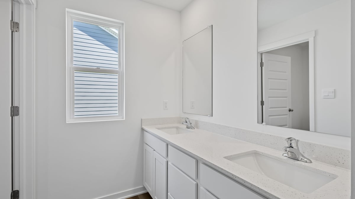 Bathroom with a dual vanity sink and a shower.