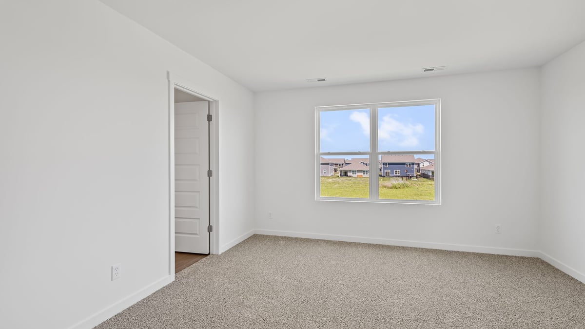 Bedroom with carpeted floors and a big window.