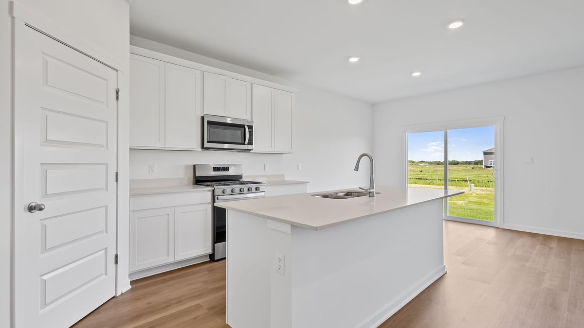 Kitchen with white cabinetry and a dining area with a glass sliding door.