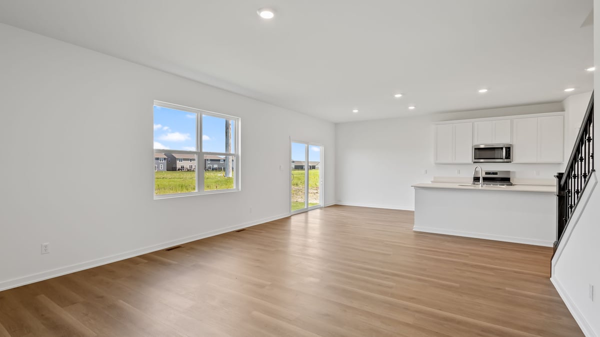 Living room space with hard wood flooring and a big window.