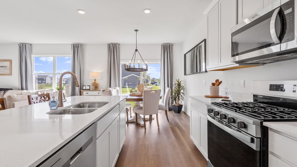 Kitchen with white cabinets with hard wood floors.
