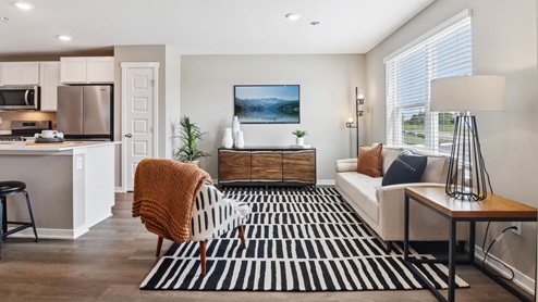 Living room with brown flooring and white walls.