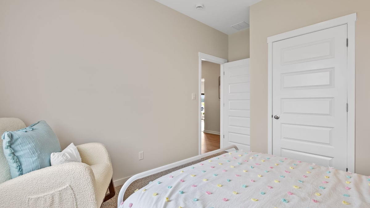 Kids bedroom with a closet and carpeted floors.