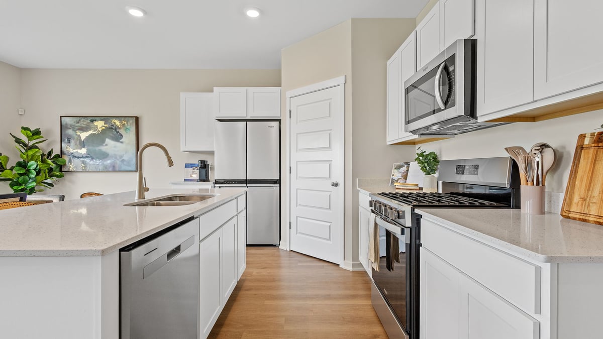 Kitchen with white cabinets and hard wood floors.