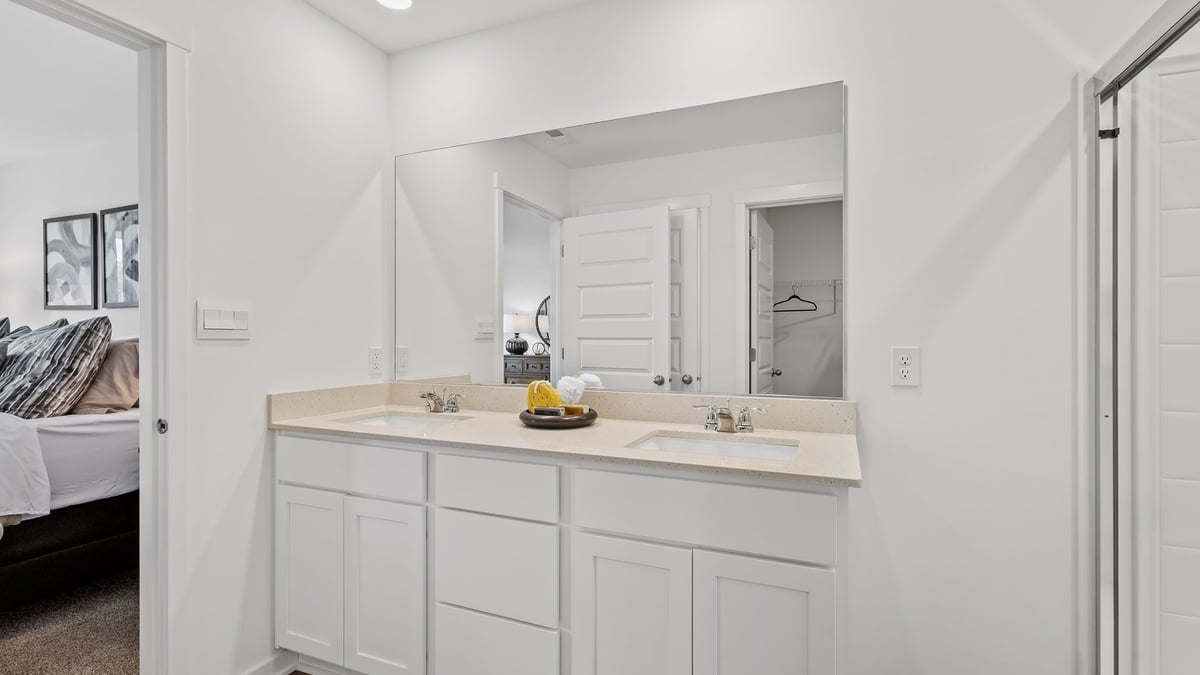 Primary bathroom with dual vanity sinks and walk-in shower.