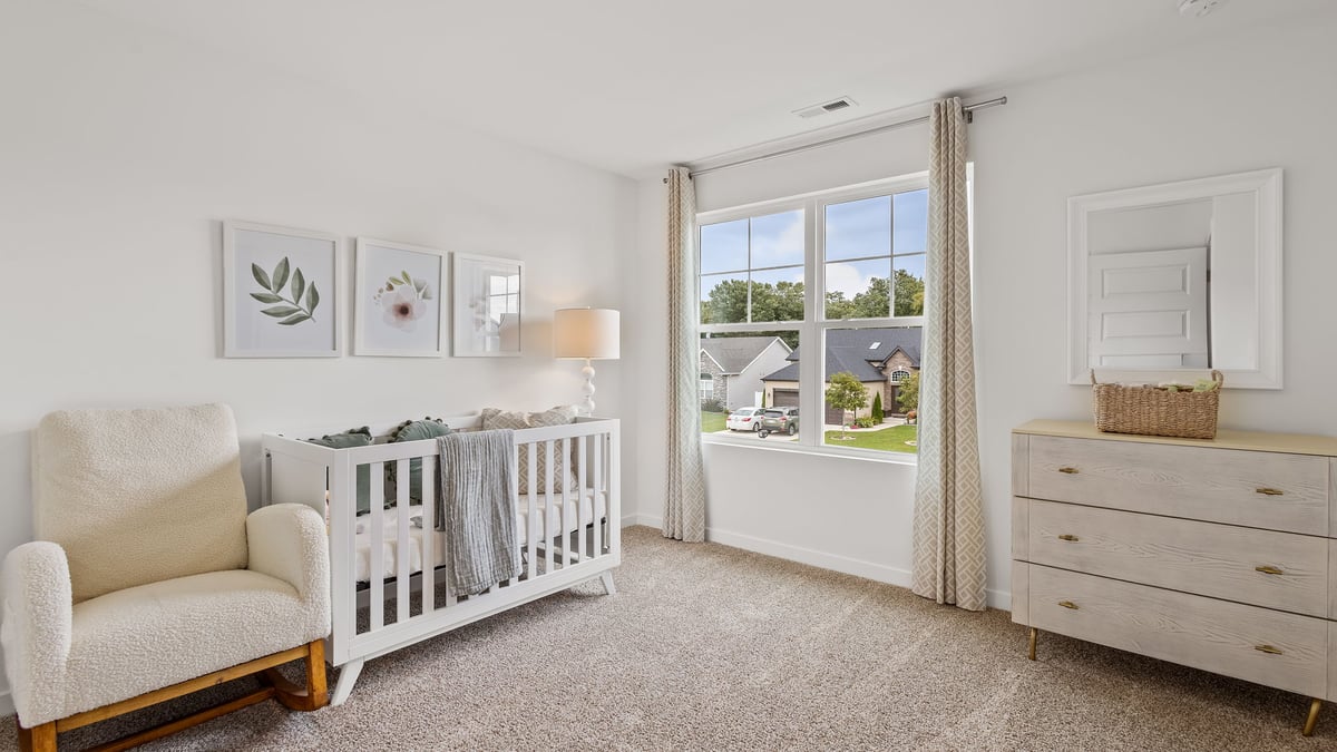 Bedroom with a large window and carpeted floors.