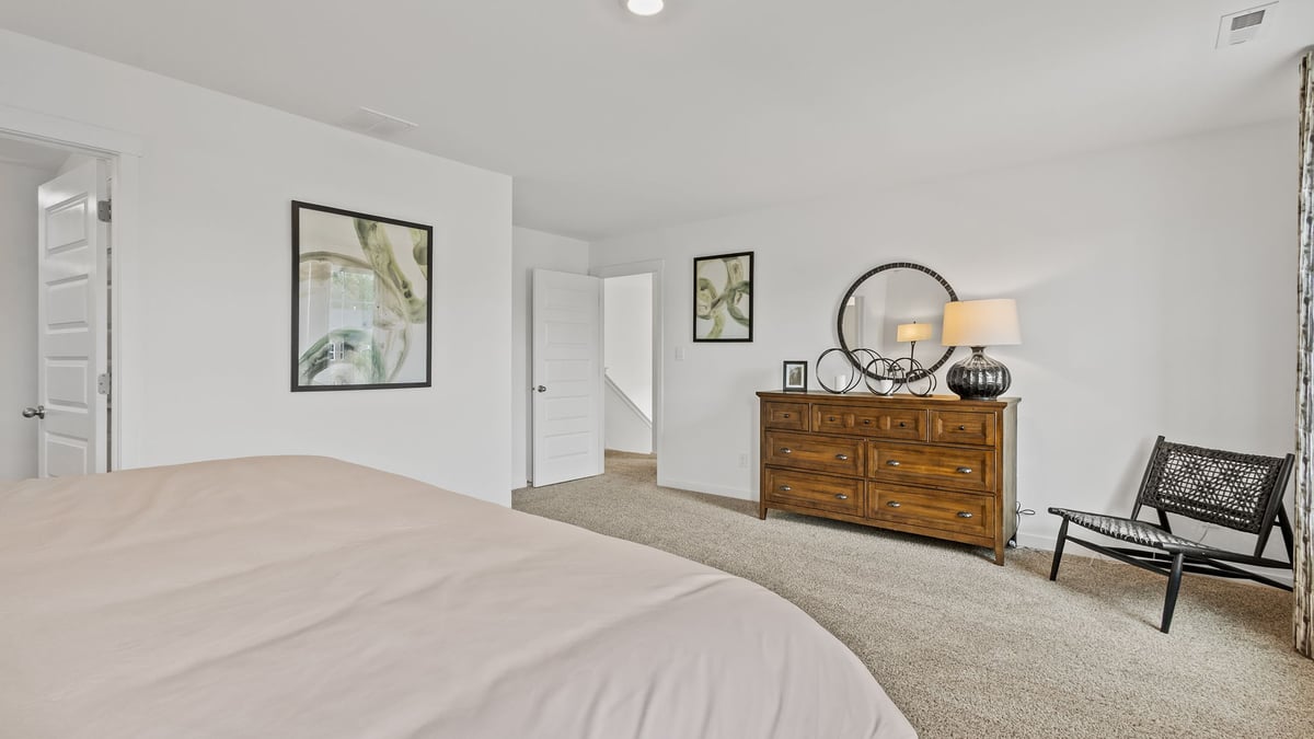 Primary bedroom with carpet and a bathroom.