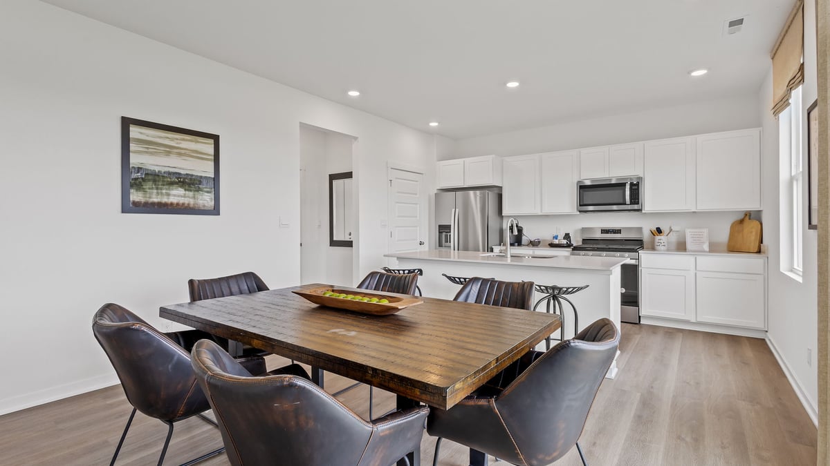 Dining area with hard wood floors and view of kitchen.