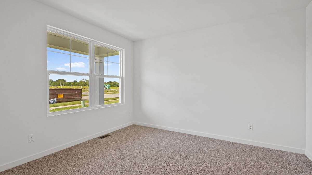 Front room with carpeted floors and a big window.
