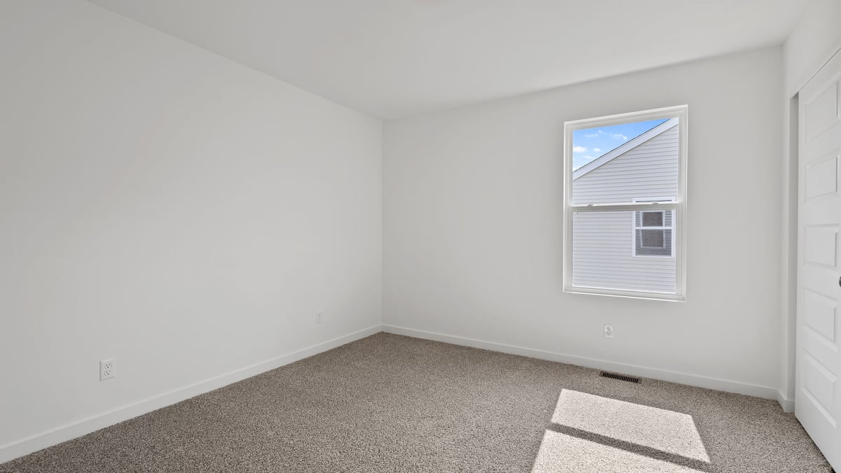 Bedroom with carpeted floors and a side window.