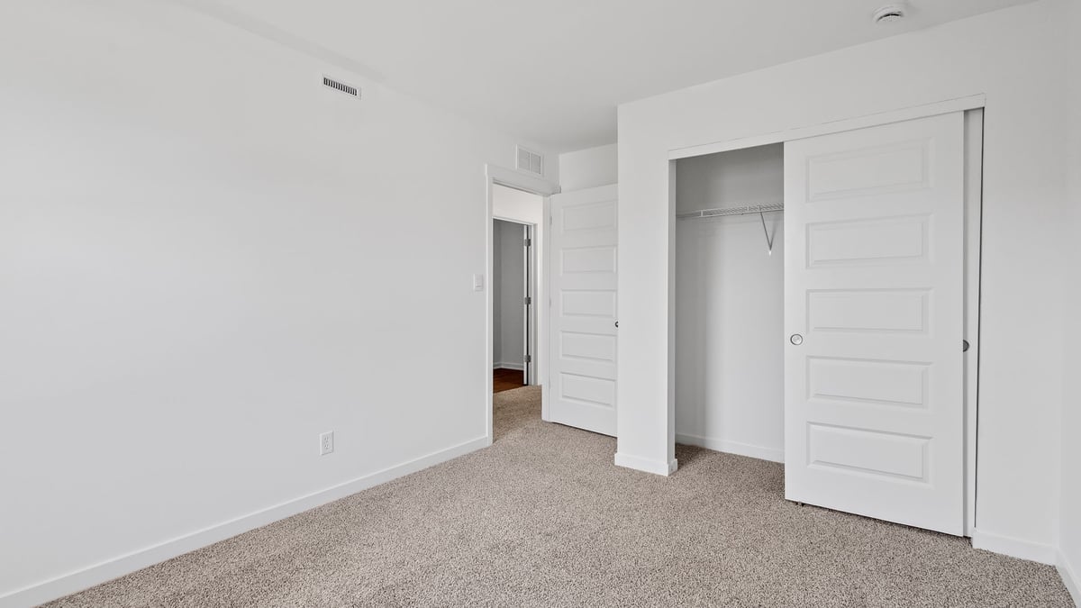 Bedroom with a closet and carpeted floors.