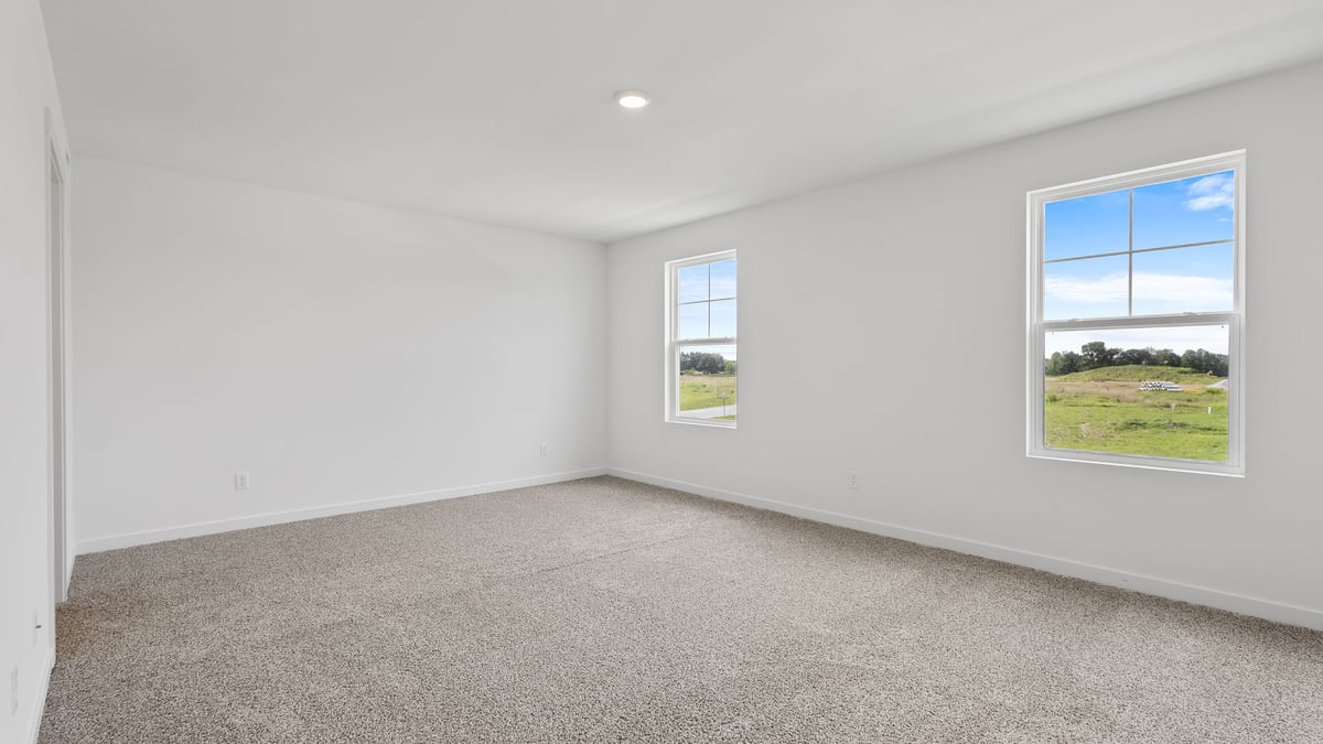 Primary bedroom with big windows.