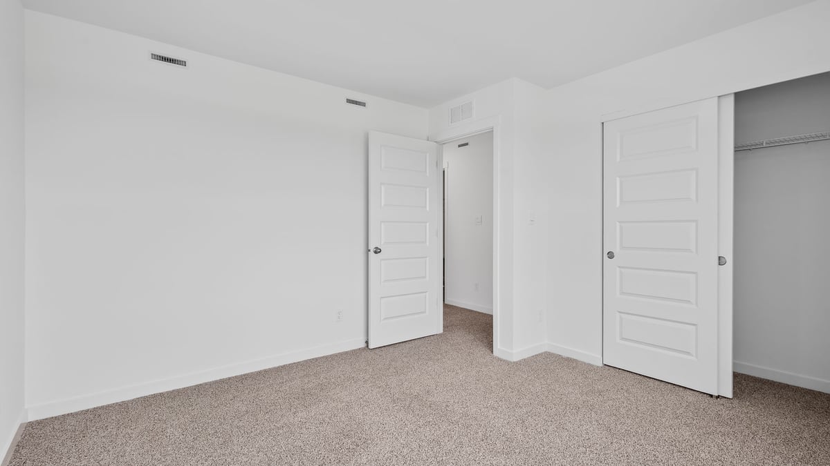 Bedroom with carpeted floors and a closet.