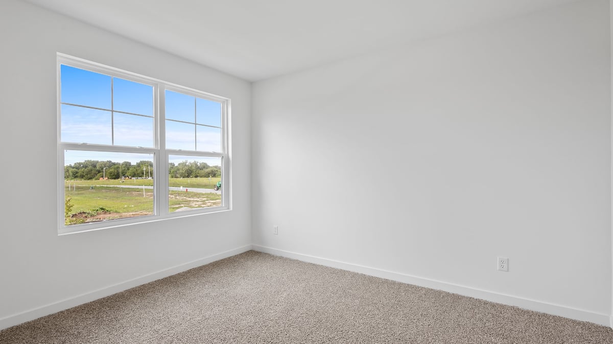 Bedroom with carpeted floors with a big window.
