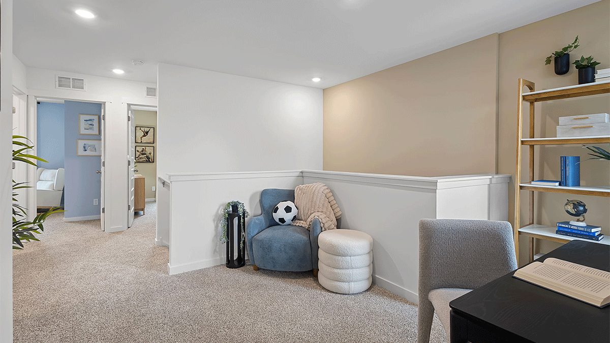 Loft area staged as a hangout area with a desk and reading nook.