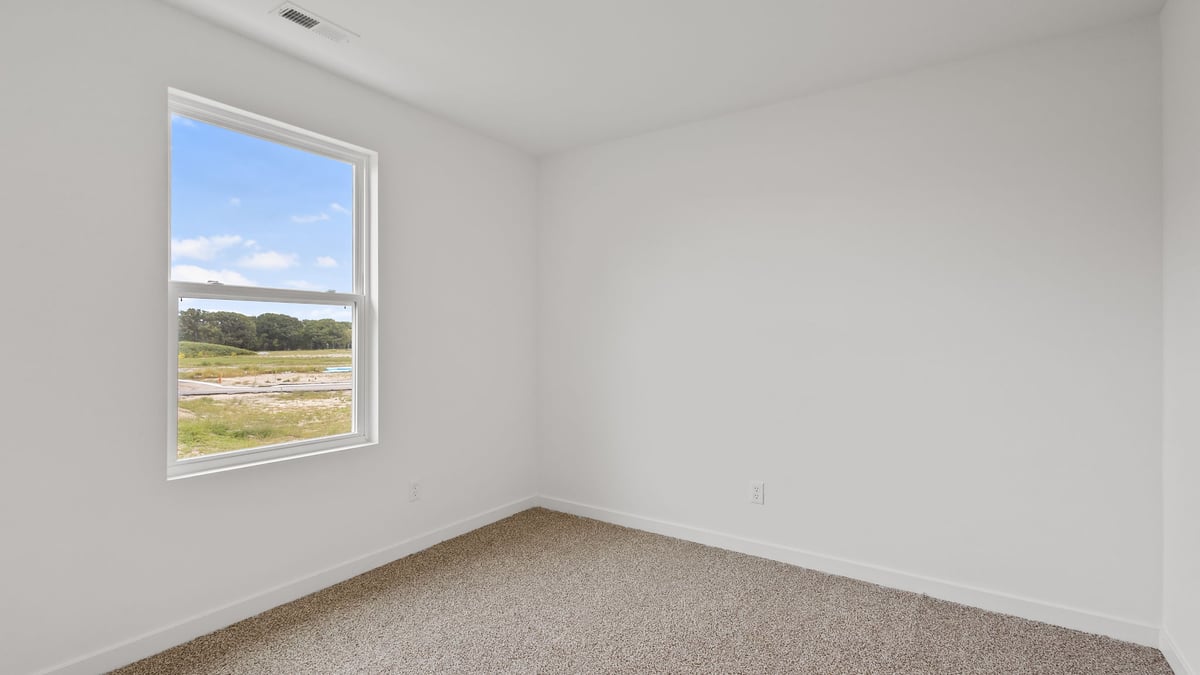 Bedroom with carpet and a window.
