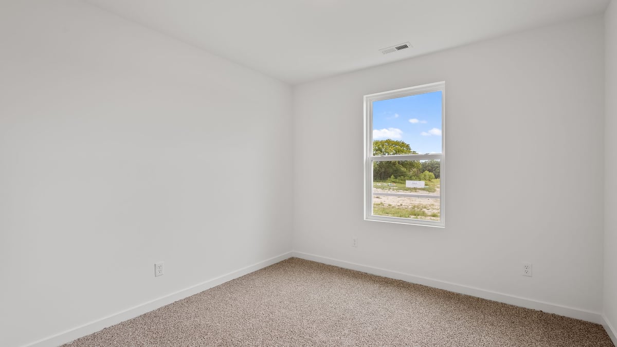 Bedroom with carpet and a side window.