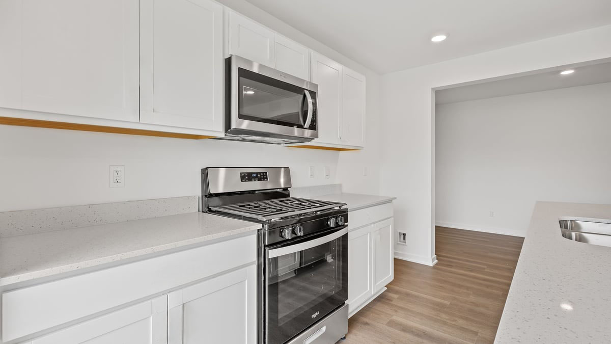 Kitchen with white cabinets with a microwave.