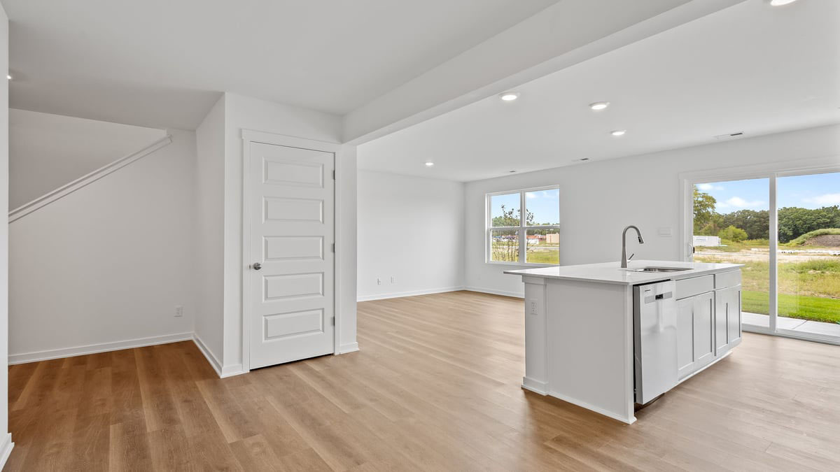 Kitchen island with hard wood flooring and windows.
