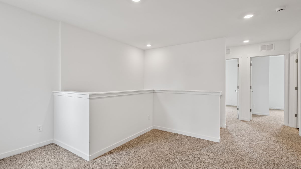 Second level with carpet and view of loft area.