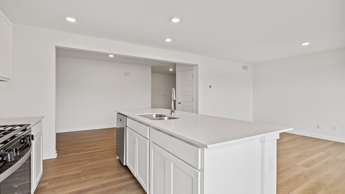 Kitchen island with quartz coutnertops and hard wood flooring.