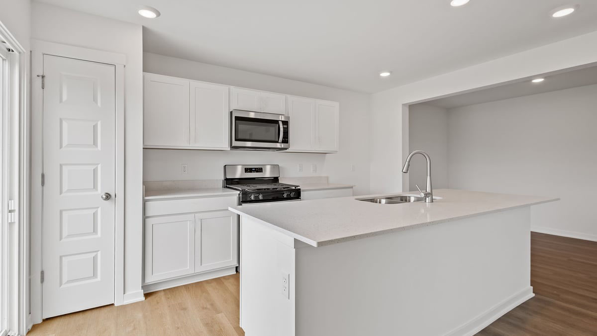 Kitchen with hard wood floors and white cabinets.