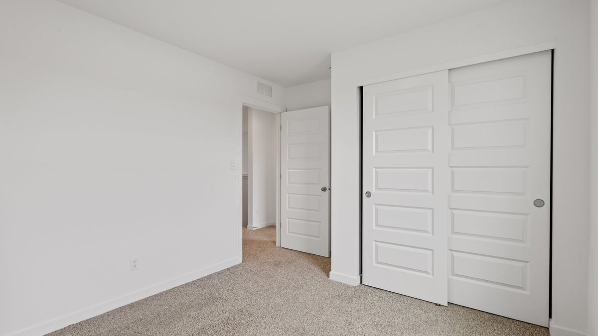 Bedroom with carpeted floors and a closet.