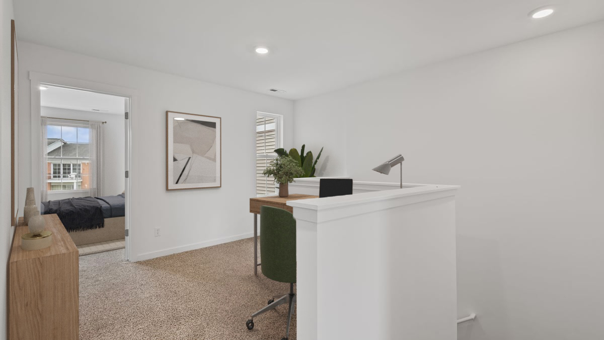 Upstairs loft area with carpeted floors as a desk area.