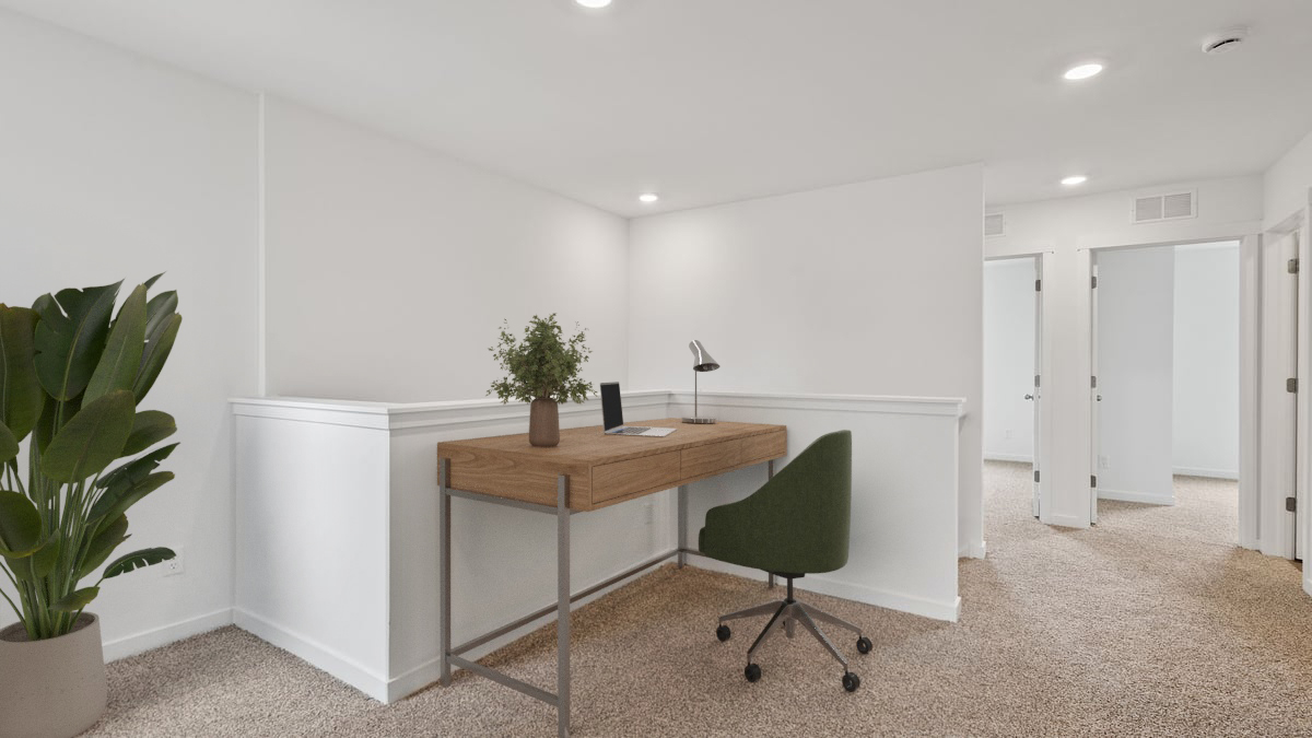 Loft area with carpeted floors and a desk area.