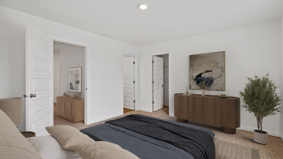 Primary bedroom with carpeted floors with a primary bathroom.