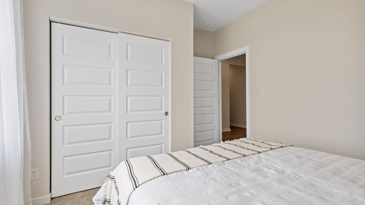 Bedroom with carpeted floors and closet.