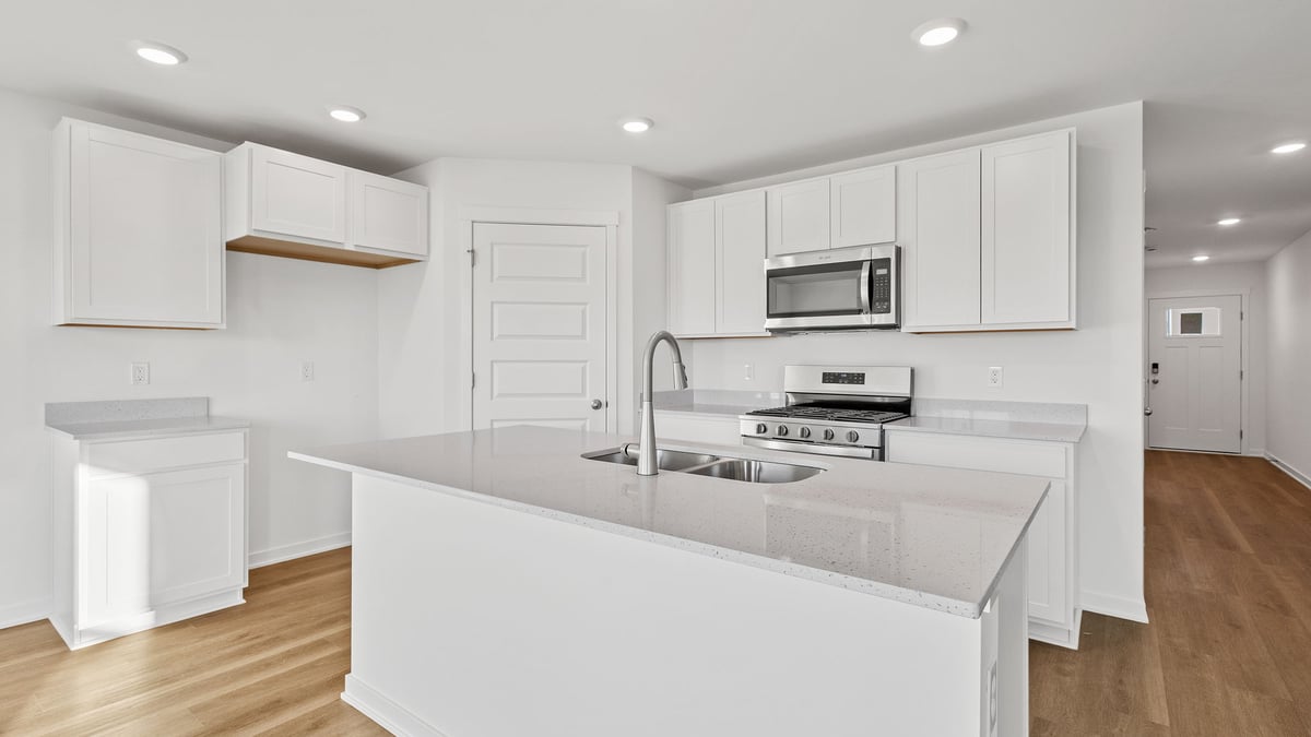 Kitchen with white cabinetry with island.