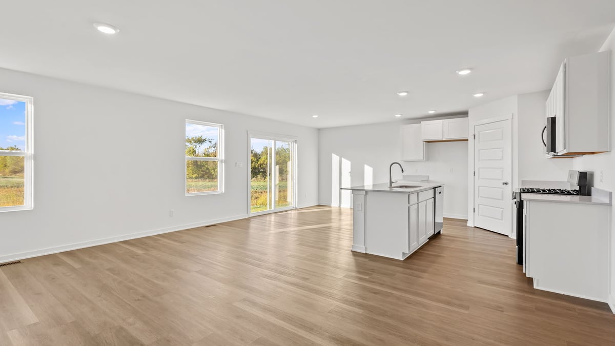 Living area with windows and view of kitchen.