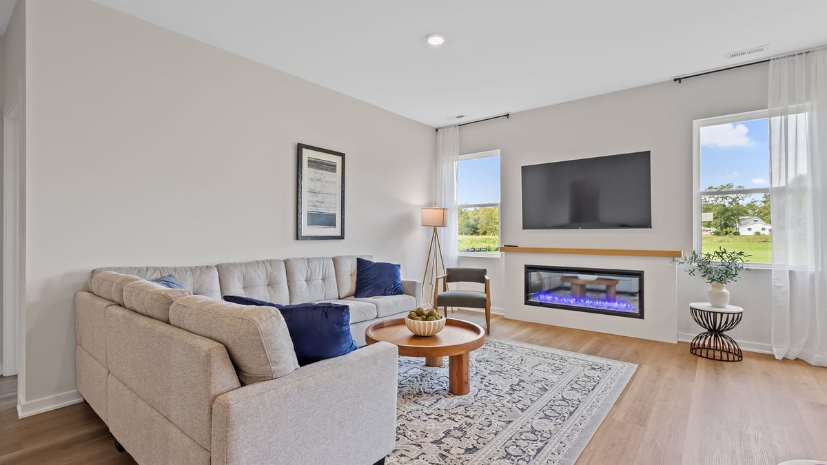 Living room area with two windows and a fireplace.