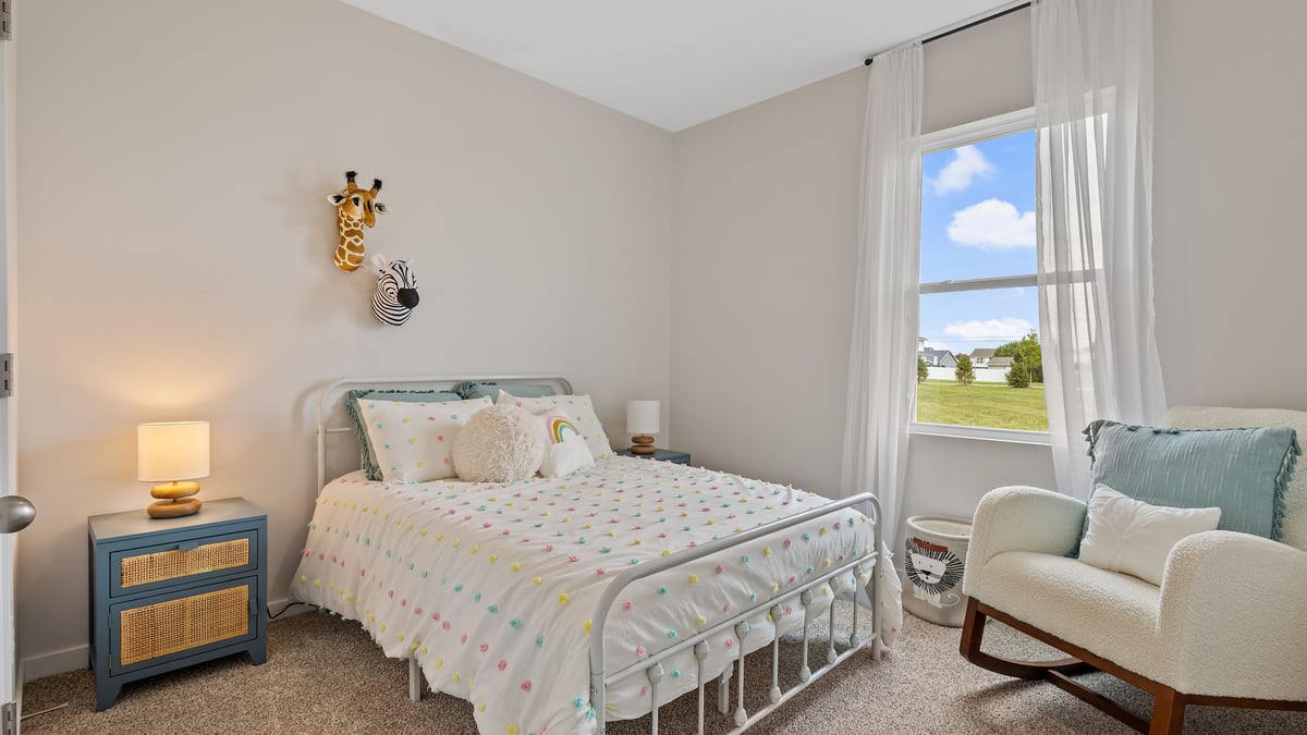 Bedroom with a side window and carpeted floors.